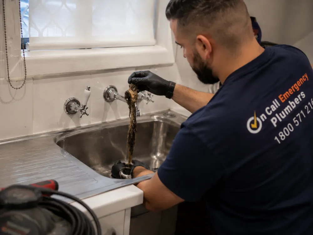Plumber clearing a kitchen sink blockage